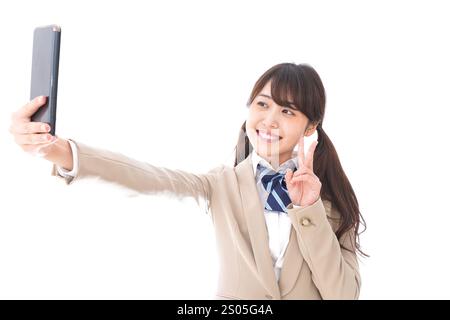 Student in school uniform using a smartphone Stock Photo