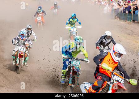 Ukraine, the city of Romny, September 05-06, 2020: Motocross racers compete on a dirt track surrounded by spectators. Outdoor sports photography captu Stock Photo