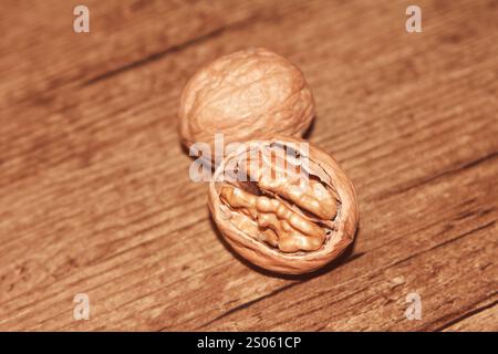A whole walnut, an open walnut with a wooden background. Stock Photo