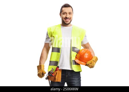 Construction worker holding a helmet, wearing a tool belt and smiling at camera isolated on white background Stock Photo