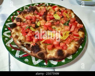 Italian Tomato Bruschetta in pizza shape antipasto served at restaurant. Stock Photo