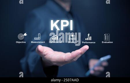 KPI key performance indicator. A businessman, in his hand, uses KPIs to measure progress of his business, project, or work over time to reach the goal Stock Photo