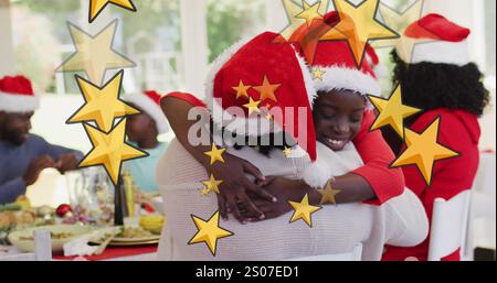 Image of stars over african american family with santa hats having christmas dinner Stock Photo