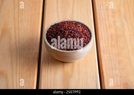 Red pepper flakes.Red chili peppers in wooden bowl on wooden table.Dried chili peppers Stock Photo