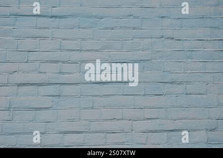 Gray textured  brick wall background. The brick wall of the house is painted light gray. Stock Photo