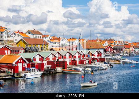 Cityscape of Smögen, Sweden, with old red painted wooden houses lined up along the sea channel in the historic center of the village on a sunny day. Stock Photo