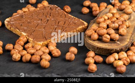 hazelnuts and bread with nut paste with chocolate closeup, delicious and chocolate butter with nuts Stock Photo