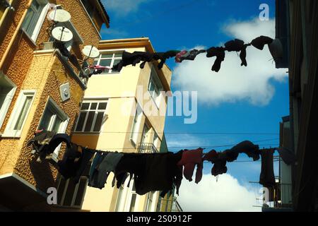 Balat, Istanbul, Türkiye - December 1, 2024: laundry clothes hanging on a narrow street between residential buildings Stock Photo