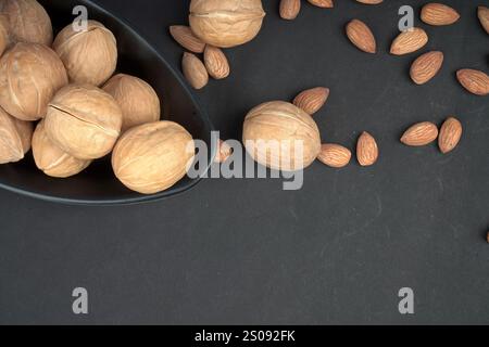 Images of dry walnut and almonds in black background from top Stock Photo
