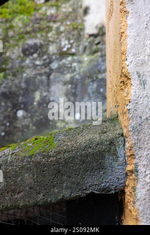 Corner detail on a wall. The wall is made of concrete and part of it is painted yellow. Image for backgrounds Stock Photo