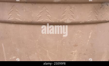 Intricate tree designs are etched into a clay surface, showcasing artistic skill and tradition. Stock Photo