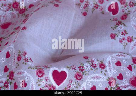 Hearts & flowers on fabric hanky handkerchief show dainty design for center text. Valentine cloth is fine linen cotton weave. Floral pattern is red. Stock Photo