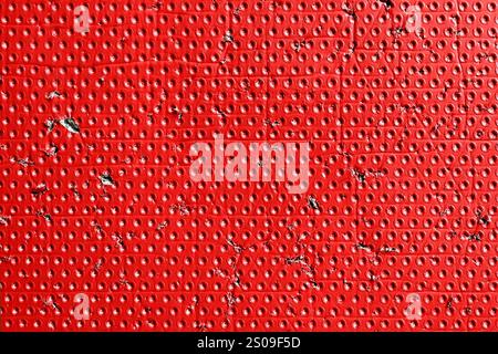Red aged textured ripped surface with dotted pattern and torn distressed details. Industrial worn scratched color background Stock Photo