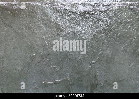 Uneven gray stone surface with natural cracks and subtle textures. Glossy organic minimalist design. Modern architectural background Stock Photo