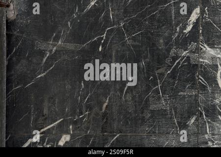 Distressed black wall with scratched patterns and worn textures. Rugged industrial gray surface. Urban-themed background Stock Photo