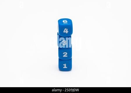 Four Blue Dice Stacked in a Tower with Numbers 1, 2, 3, and 4 Facing Camera Stock Photo