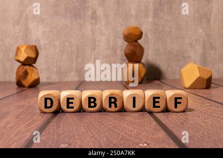 Debrief symbol. Concept word Debrief on wooden blocks. Beautiful grey green background. Business and Debrief concept. Copy space. Stock Photo