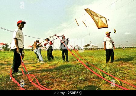 Men flying kite during the 2004 Jakarta International Kite Festival that held on July 9-11 at Carnival Beach in Ancol Dreamland, North Jakarta, Jakarta, Indonesia. Stock Photo