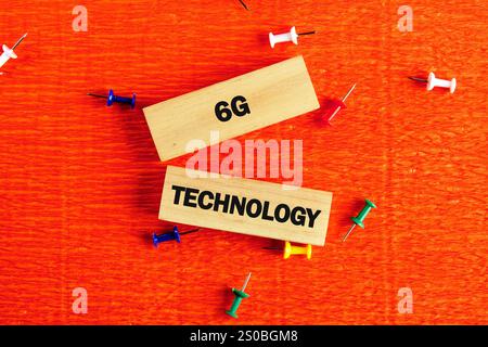 Blocks labeled with 6G and technology rest on a bright orange surface, enhanced by assorted colorful push pins scattered around them, symbolizing inno Stock Photo
