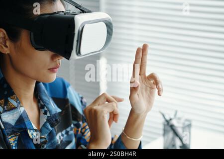 Asian Woman Using VR Headset In Office Stock Photo