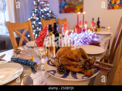 A table laid for Christmas lunch with crackers and a roast Turkey. A family enjoying Christmas lunch. Stock Photo