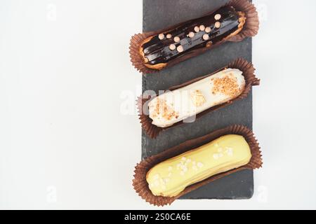 Three eclairs on a black tray top view Stock Photo