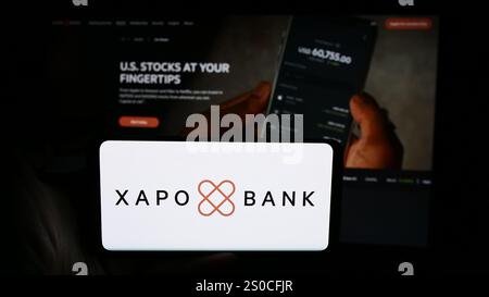 Germany. 3rd July, 2024. In this photo illustration, a person is holding a cellphone with the logo of crypto banking company Xapo Holdings Limited in front of business webpage. (Credit Image: © Timon Schneider/SOPA Images via ZUMA Press Wire) EDITORIAL USAGE ONLY! Not for Commercial USAGE! Stock Photo
