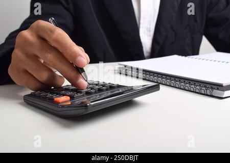Accountant Businessman analyzes Invoice investment graph and presses calculator button on document. Accounting Bookkeeper Bank Advisor And Auditor. Stock Photo