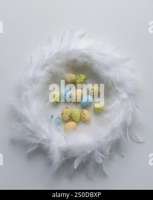 Speckled Easter Eggs in Feather Nest on White Background Stock Photo