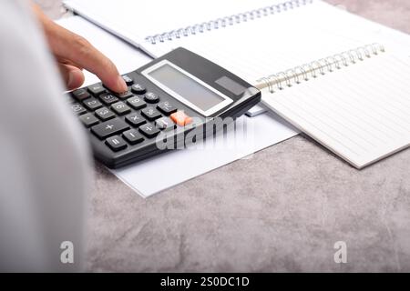 Businessman with calculator. Calculating household finances and writing notes, desk accounting, budget management. Doing finances, budgeting and tax c Stock Photo