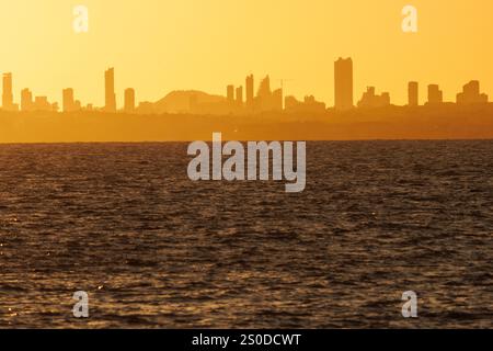 Sunset with the urban skyline of Benidorm city from the seafront of the Peon de Ifach in Calpe, Spain Stock Photo
