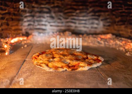 Pizza Baking in a Rustic Wood-Fired Oven Stock Photo