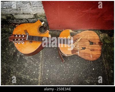 A broken acoustic guitar dumped on the pavement Stock Photo