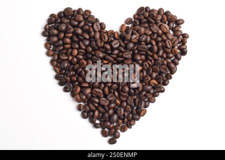 Roasted coffee beans arranged in heart shape isolated on white background. Stock Photo
