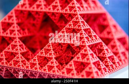 Art object printed on 3D printer from red melted plastic close-up. Model of pyramid created on 3D printer from plastic. 3D Printing technology. Additive progressive technology. New modern technologies Stock Photo