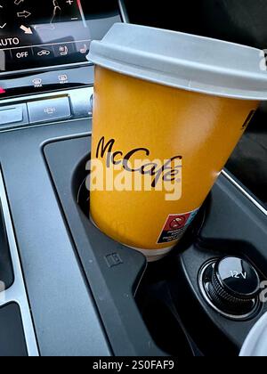 A coffee by McCafe in a paper cup for takeaway in the holder of a car Stock Photo