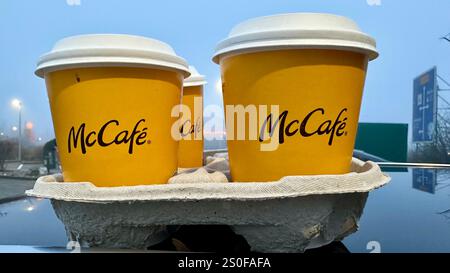 Four coffees by McCafe in paper cups for takeaway on a car roof Stock Photo