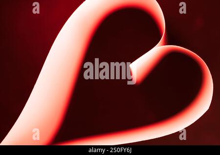 Abstract of heart shape bathed in pink red gradients on a glowing background Stock Photo