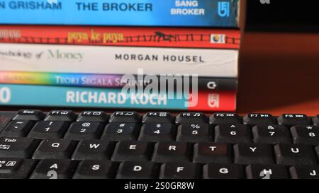 Stack of books on wooden table and black keyboard, back to school concept Stock Photo