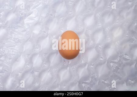 Chicken egg on air cushion bubble wrap background Stock Photo