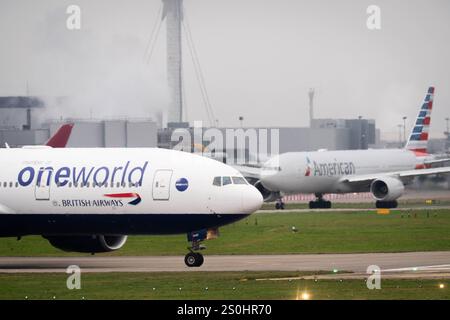 A British Airways Boeing B777-200ER and an American Airlines Boeing B777-300ER on the taxiway at Heathrow Airport, west London. Picture date: Saturday December 28, 2024. Stock Photo