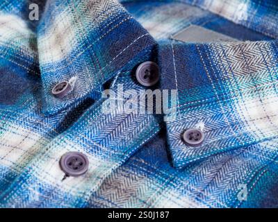 Close-up of a blue and white checkered flannel shirt collar with buttons. Stock Photo