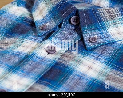 Close-up of a blue and white plaid button-up shirt, highlighting the texture. Stock Photo