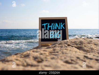 Think big symbol. Concept words Think Big on black chalk background. Beautiful sea background. Business and Think big concept. Copy space. Stock Photo