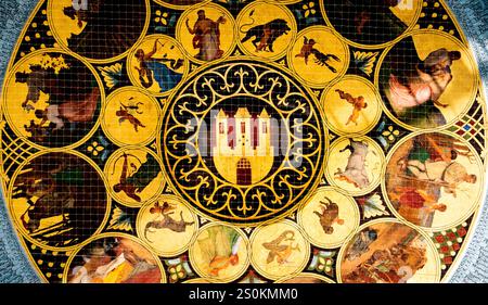A detailed circular fresco featuring various zodiac signs and mythological figures, surrounded by ornate patterns and a central emblem of three towers Stock Photo