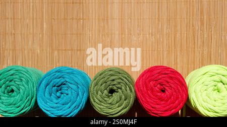 Colored skeins of thread for weaving macrame on a wooden surface. Stock Photo