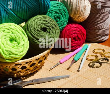 Colored skeins of thread for weaving macrame and boxes with accessories. Bright thread macro on a wooden background. Stock Photo