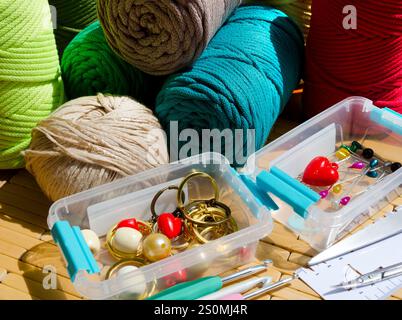 Colored skeins of thread for weaving macrame and boxes with accessories. Bright thread macro on a wooden background. Stock Photo