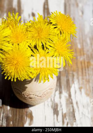 Bouquet of dandelions on the window in a transparent vase. Still life ...