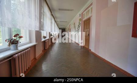 Sunlight shining through windows in an empty school corridor, evoking nostalgia on the final day of school Stock Photo